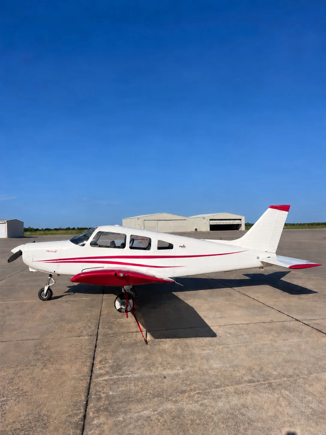 Piper Warrior III with white and red livery on an airport apron